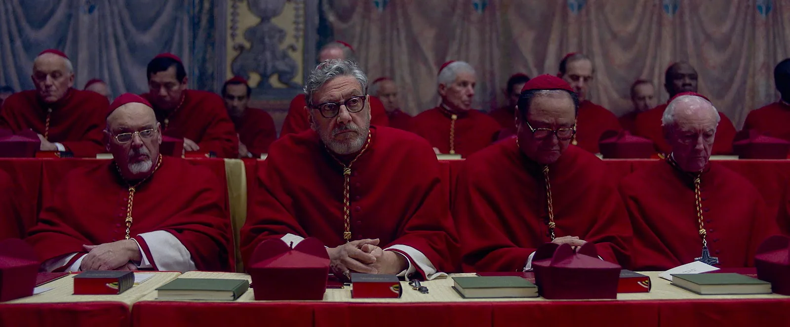Sergio Castellitto as Cardinal Tedesco in heavy formal vestments against a dark interior
